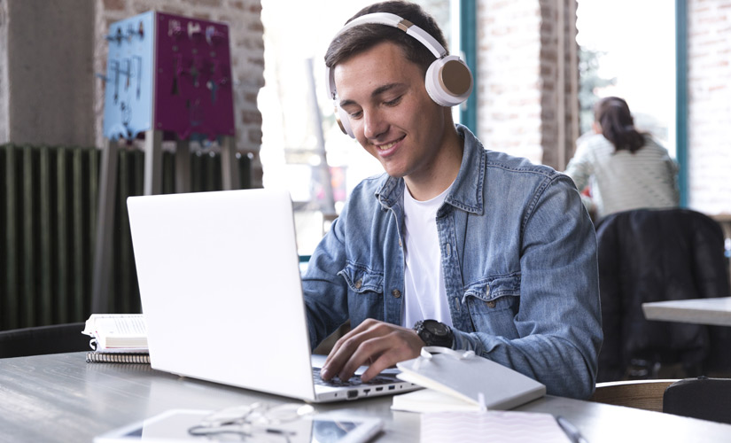 Chico estudiando con auriculares