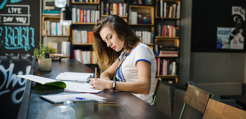chica en la biblioteca estudiando